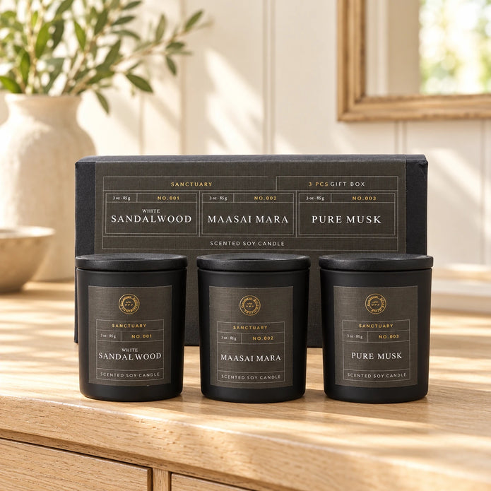 Sanctuary Candles Gift Set - Set Of Three — All three closed jars placed in a row on pale oak console with original gift box behind