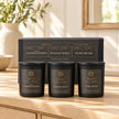 Sanctuary Candles Gift Set - Set Of Three — All three closed jars placed in a row on pale oak console with original gift box behind