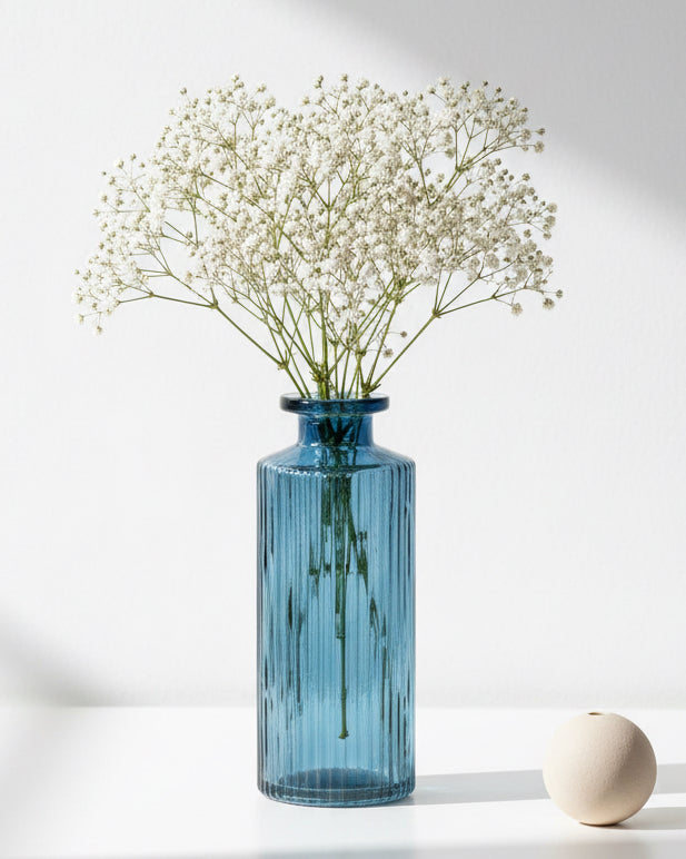 Blue glass bottle bud vase for home decor by Satchville, featuring a sleek, modern design perfect for floral arrangements.