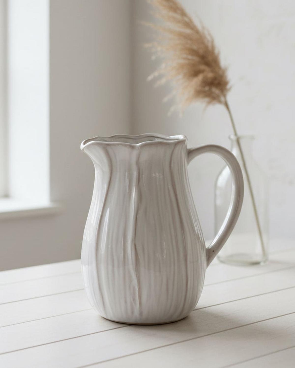 Natural ceramic jug with petal-shaped design, ideal for home decor, by Satchville, featuring elegant, handcrafted floral-inspired details.