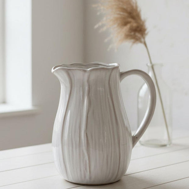 Natural ceramic jug with petal-shaped design, ideal for home decor, by Satchville, featuring elegant, handcrafted floral-inspired details.