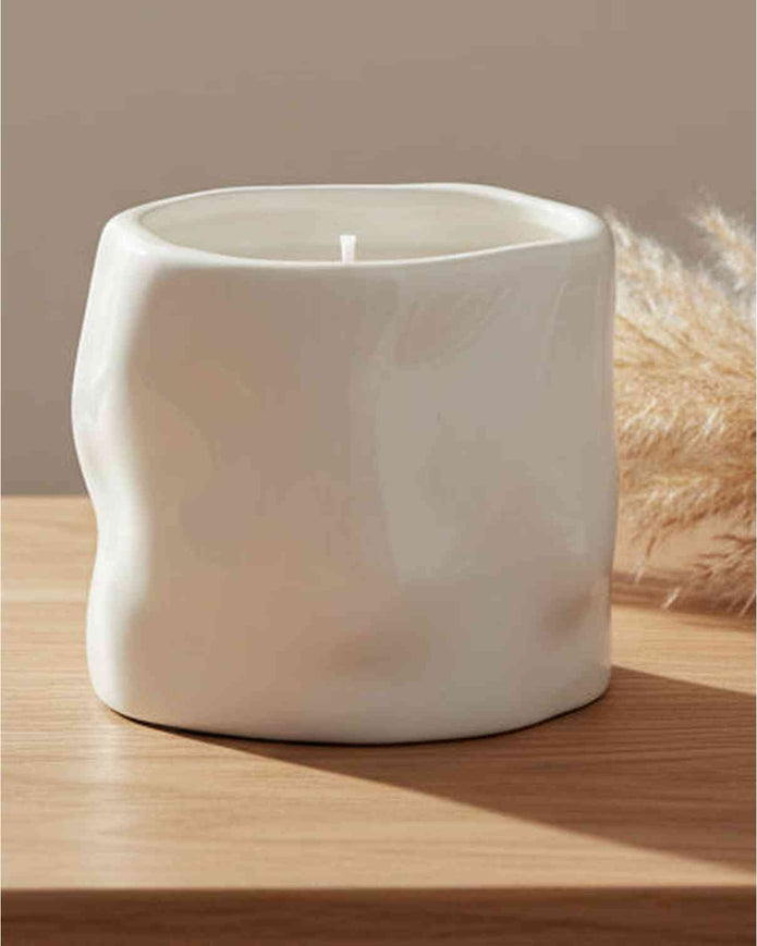 White sculpted candle by Satchville, a stylish home decor piece featuring intricate carvings and a smooth finish.