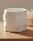 White sculpted candle by Satchville, a stylish home decor piece featuring intricate carvings and a smooth finish.