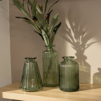 Olive green glass bottle bud vase by Satchville, featuring a sleek home decor design with a triangular shape and smooth finish.