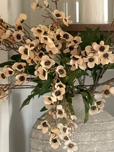 Artificial Daisy Flower Stem in peach from Starlight Express, displayed in a tall white textured vase.
