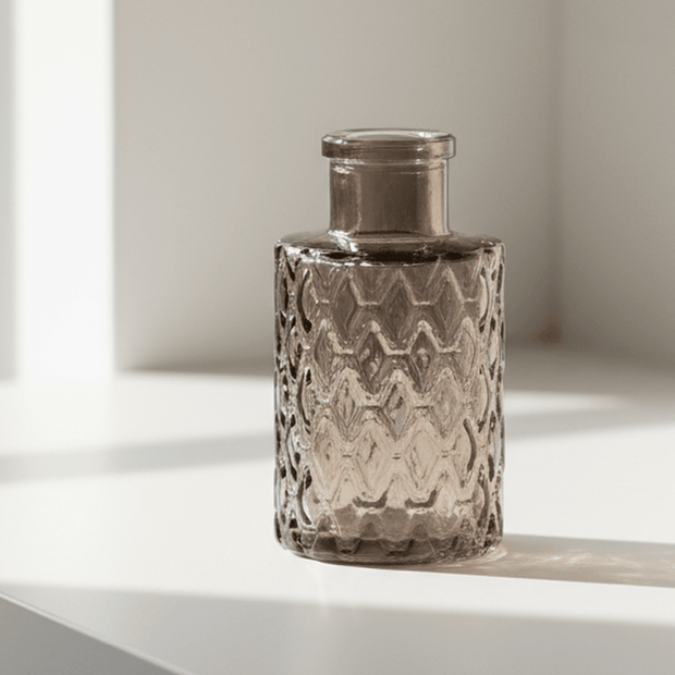 Warm grey glass mini bottle bud vase by Satchville, featuring a compact, elegant design perfect for small floral arrangements.