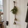 Hanging bells with greenery and white berries on a cream panelled door