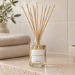 Heaven Scent SEA SALT & SPRAY 100ml reed diffuser styled on a stone bathroom shelf with reeds inserted.