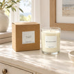 Heaven Scent Sea Salt & Spray Medium Candle, unlit with its brown kraft box on a cream console