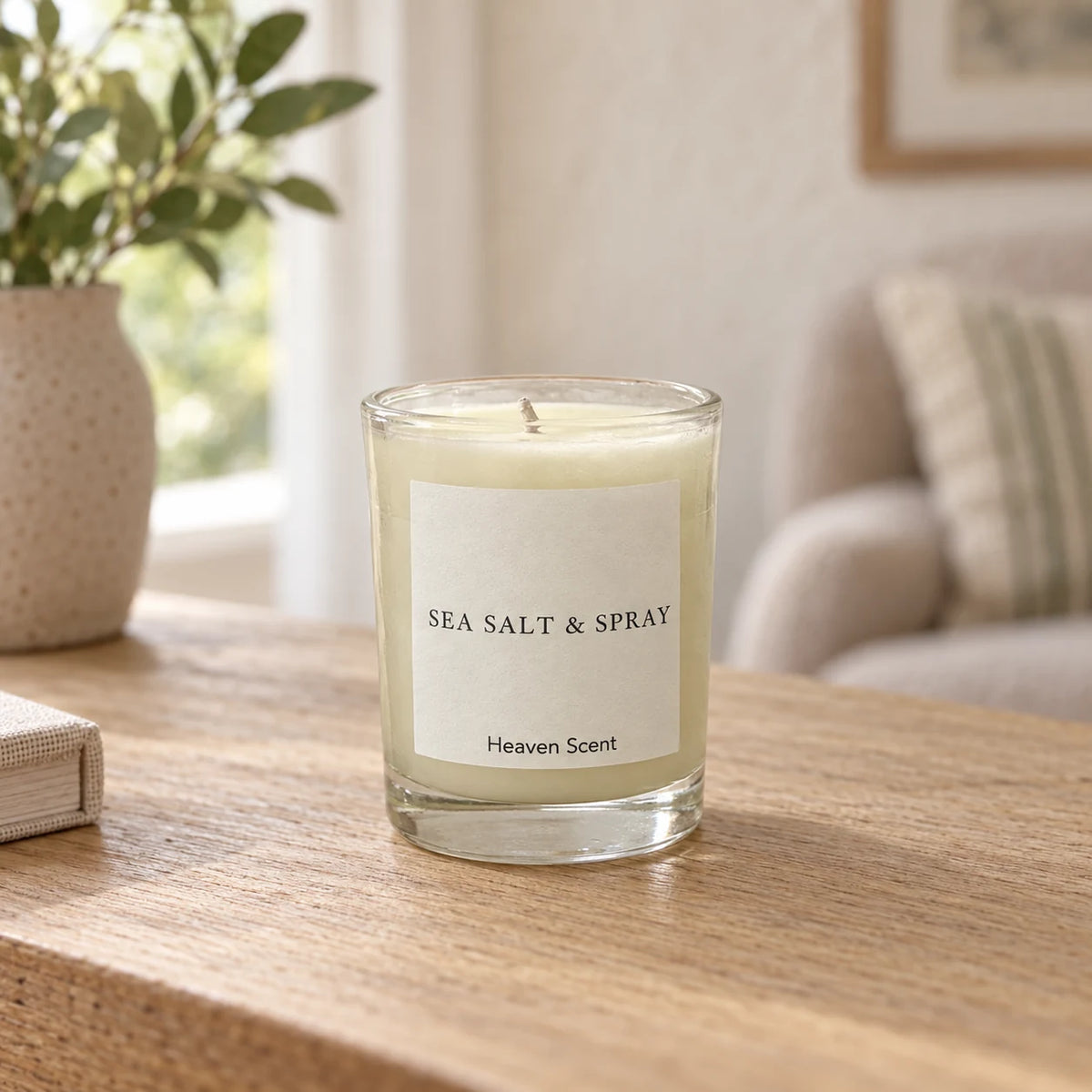 Heaven Scent Sea Salt & Spray Small Candle, ivory wax in clear glass on an oak console