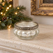 One empty silver mercury glass tealight holder on a festive limestone mantel.
