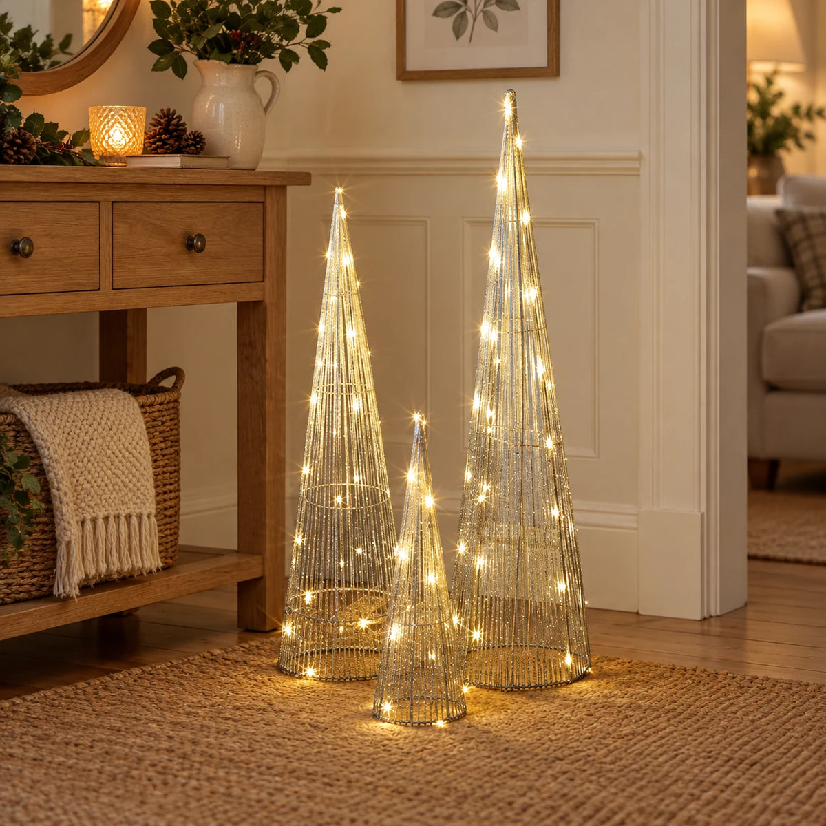 Three silver TreeBelisk cone trees glowing beside an oak console.