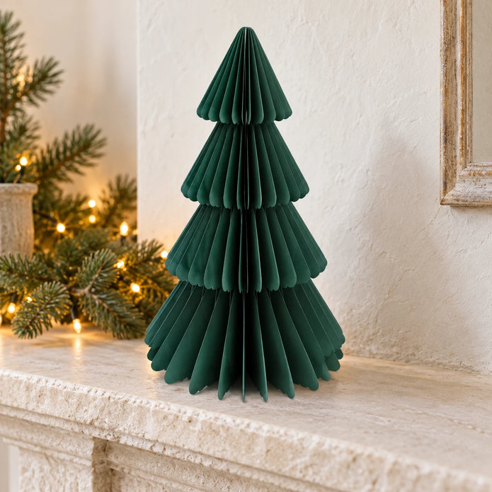Green paper Christmas tree displayed on a stone mantel.