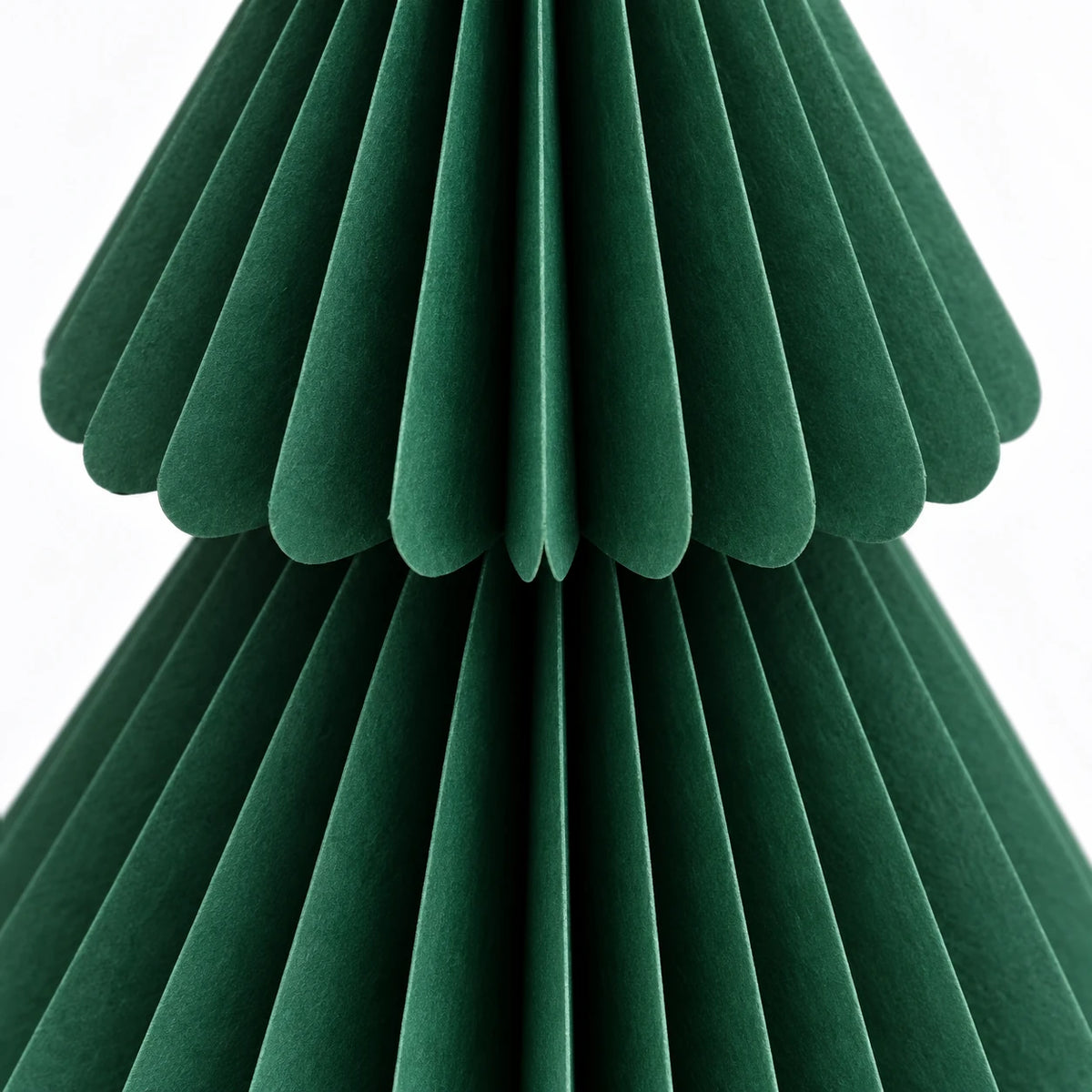 Close detail of green paper folds and scalloped tier edges.