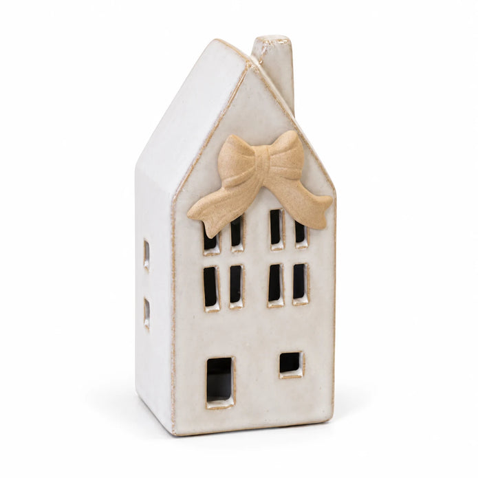 Small ceramic Dutch LED house with beige bow detail, unlit on a white background.