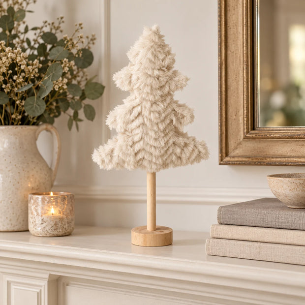 Small cream fluffy tree on a cream mantel.