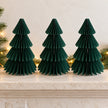 Three equal-sized green paper Christmas trees side by side on a stone mantel.