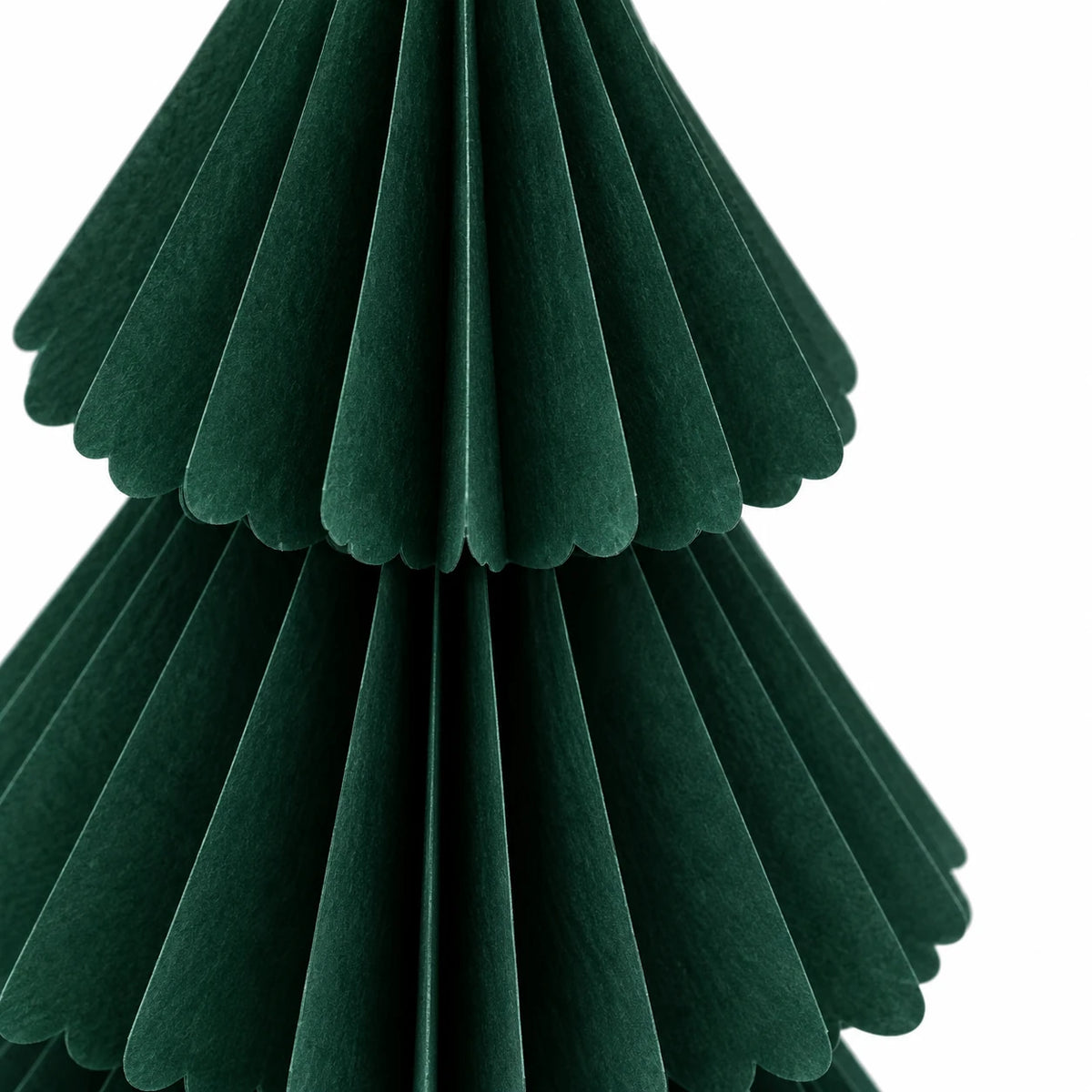 Close-up of dark green paper folds and scalloped tier edges.