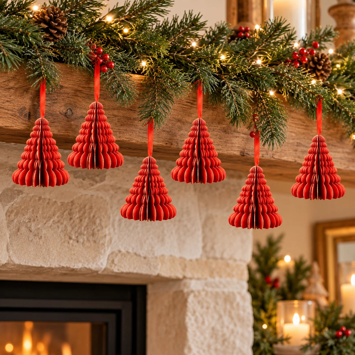 Six small red paper Christmas trees suspended beneath a festive mantel garland.