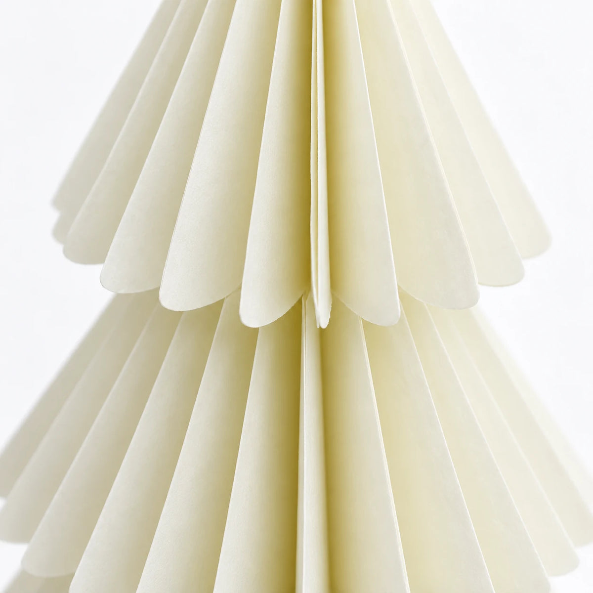 Close-up of winter white paper folds and scalloped tier edges.