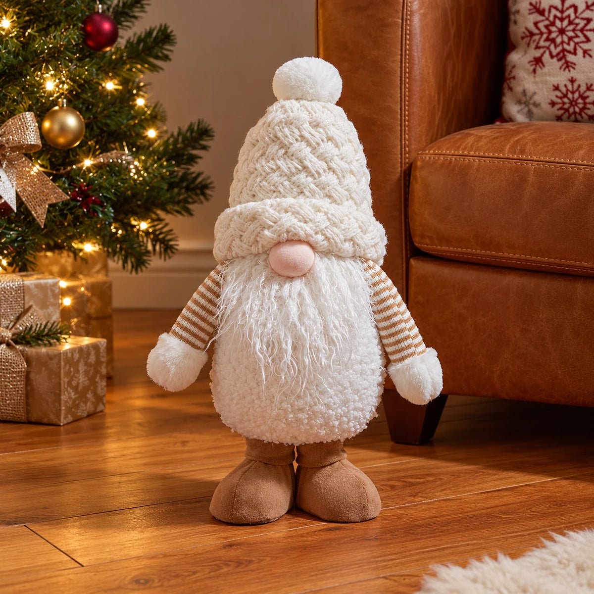 Medium snowy white gonk beside a leather armchair.