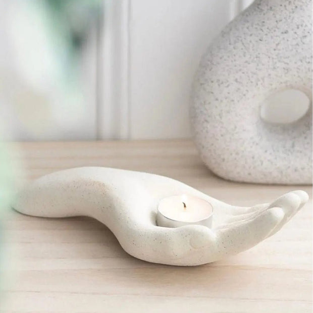 Neutral open hand tealight holder, decorative home decor piece by Something Different Wholesale, designed to hold tealights.