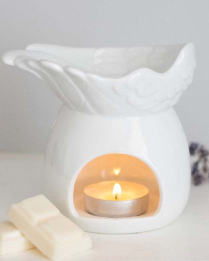 White ceramic angel wings dish wax melt burner for candles and wax melts, featuring a decorative angel wing design.