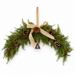 Spruce arched Christmas swag with red berries, pinecones, hessian bow and hanging bell on white background