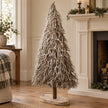 Standing white and natural twig tree beside a cream mantel.