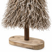 Close-up of original oval wooden base and brown trunk on Standing White And Natural Twig Tree.