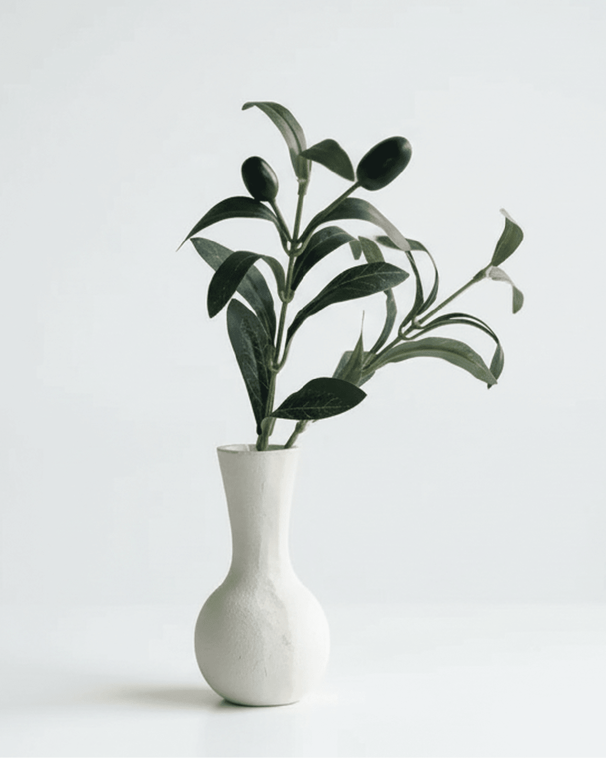 Mini artificial olive branch from Starlight Express with realistic green leaves, ideal for home or office decor.