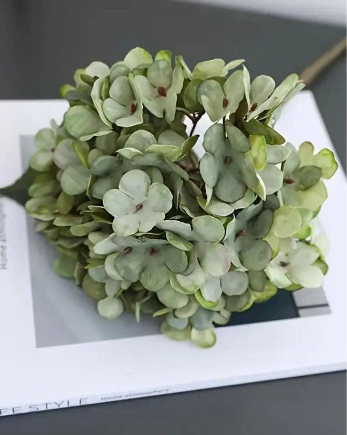 Artificial short sage green hydrangea stem from Starlight Express, realistic green foliage and delicate flower clusters.