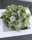 Artificial short sage green hydrangea stem from Starlight Express, realistic green foliage and delicate flower clusters.