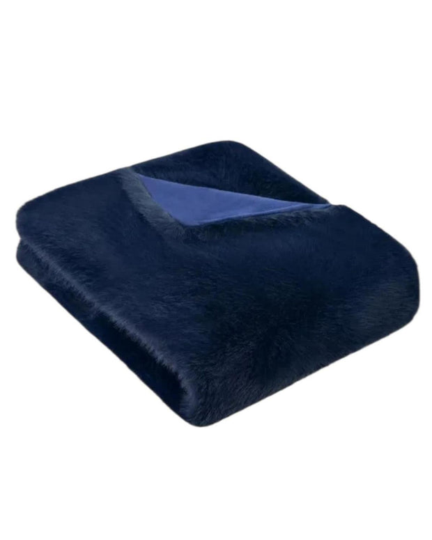 Navy blue Jasper blanket throw by Starlight Express, soft woven fabric with fringed edges, draped over a cozy armchair.