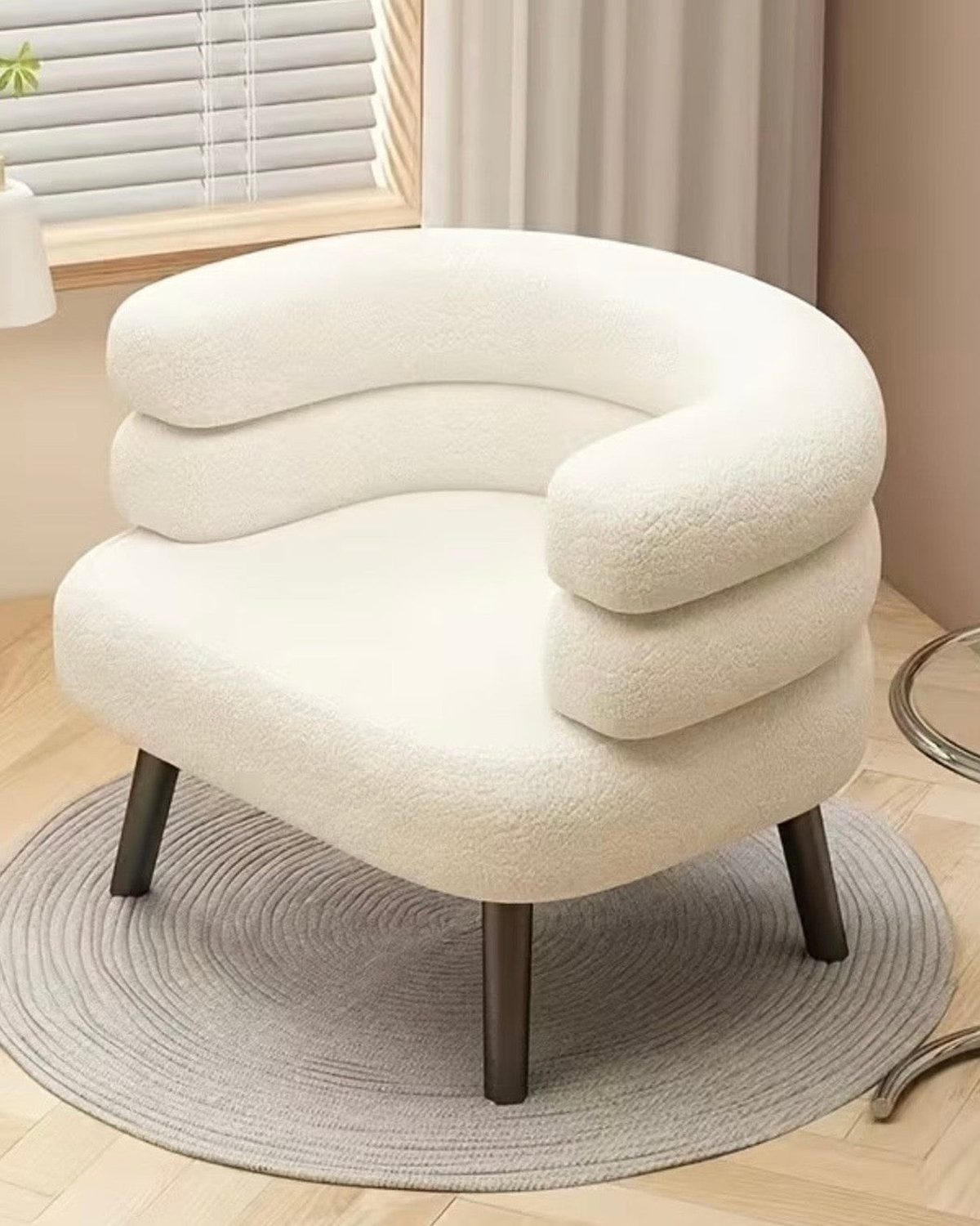 Cream boucle curved chair with wooden legs from Starlight Express, showcasing its plush upholstery and modern design.