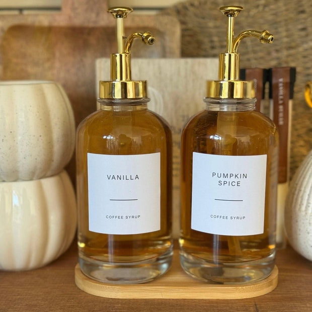 Gold coffee syrup dispenser and label set by Starlight Express, kitchen accessory for coffee stations, with pump and labeled bottles.