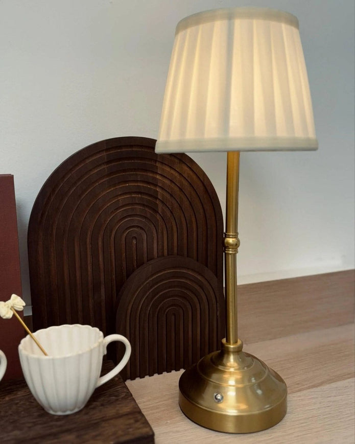 Starlight Express LED touch desk lamp with a cream pleated shade providing soft, adjustable lighting for a workspace.