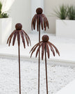 Rusty metal flower head garden stake by Starlight Express, outdoor decor with detailed flower design for garden embellishment.