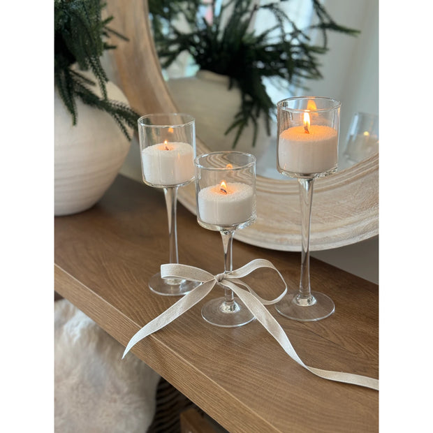 Stemmed Glass Candle Holders - Set of Three, three stemmed glass candle holders with lit candles and white ribbon