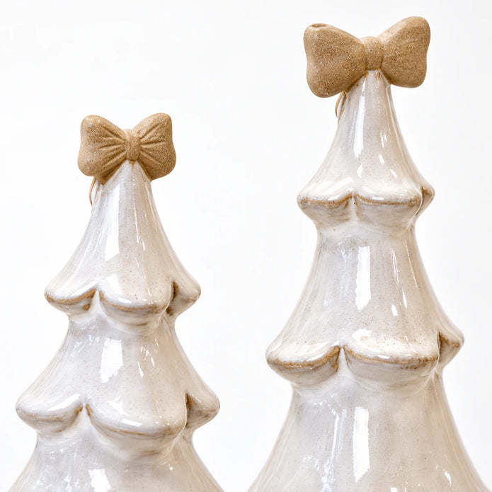 Medium and large stone-glazed ceramic Christmas trees with cream bows, showing a close-up of their ceramic bows and scalloped branches.