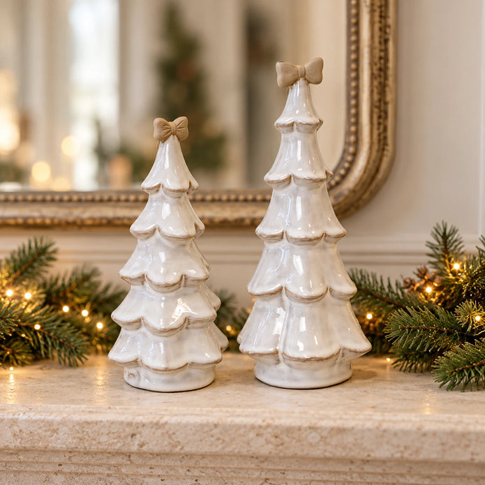Medium 20cm and large 25cm stone-glazed ceramic Christmas trees with cream bows, styled together on a festive mantel.
