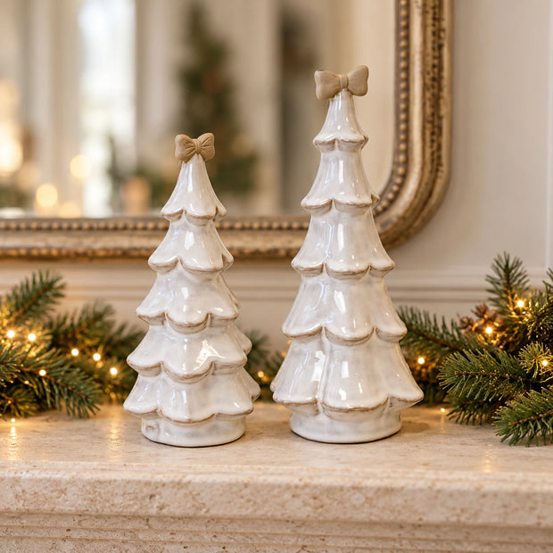 Medium stone-glazed ceramic Christmas tree by Satchville with a cream bow on top, decorated for the holiday season.