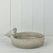 Stoneware bird bath bowl with sculpted bird on rim against a white studio background