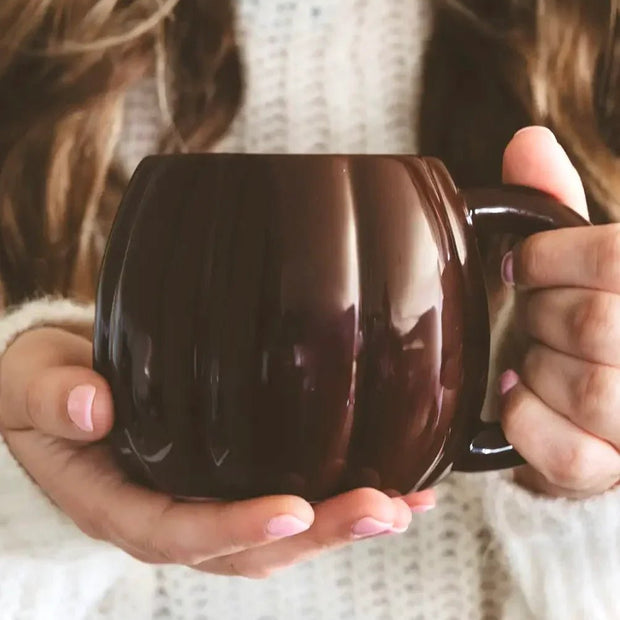 Brown ceramic pumpkin mug by Sweet Water Decor, perfect for autumn décor and cozy seasonal drinks.
