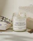 Clear glass candle jar by Sweet Water Decor featuring driftwood and mahogany, styled with a candle inside.