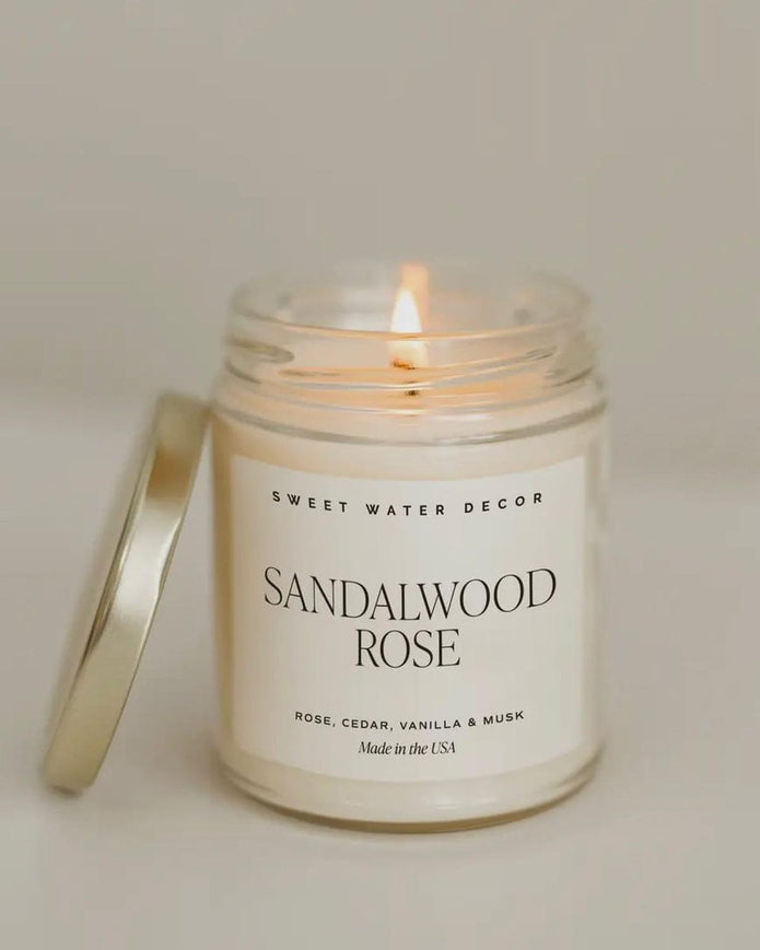 Sweet Water Decor clear glass candle jar with sandalwood rose scented candle, showcasing elegant design and natural fragrance.