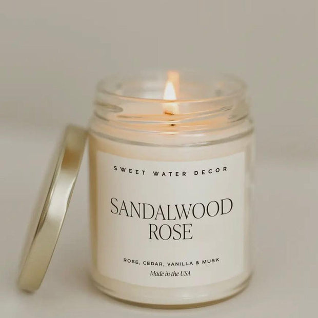Sweet Water Decor clear glass candle jar with sandalwood rose scented candle, showcasing elegant design and natural fragrance.
