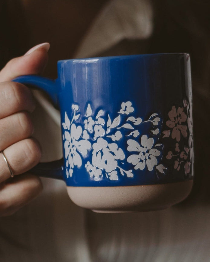 Blue floral stoneware coffee mug by Sweet Water Decor with a modern, decorative design and sturdy handle.