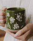 Green floral stoneware coffee mug by Sweet Water Decor, featuring a decorative design for kitchen and dining use.