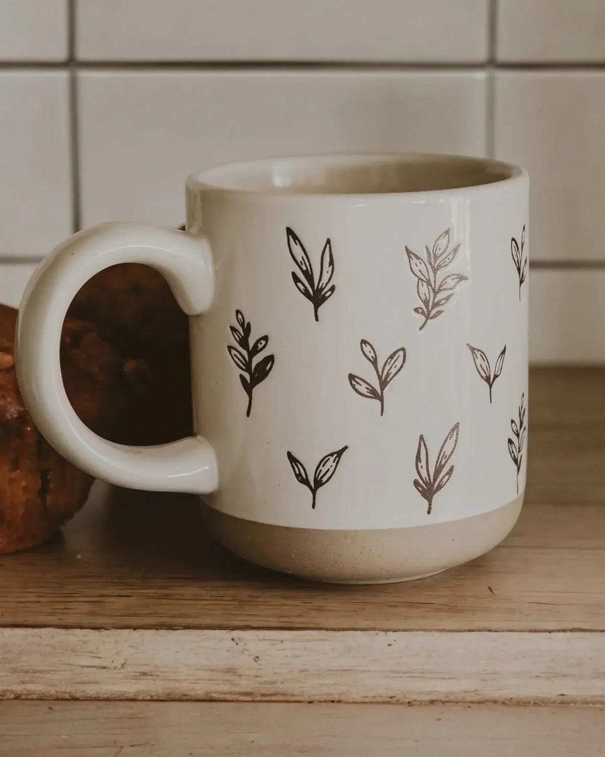 Cream glazed ceramic mug with brown leaf design by Sweet Water Decor, perfect for kitchen and dining use.